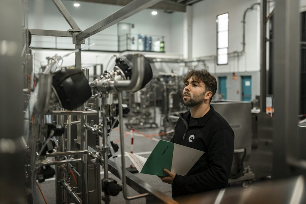 Technician performing quality control inspection in a bright modern factory