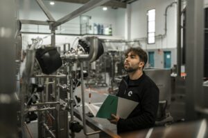 Technician performing quality control inspection in a bright modern factory