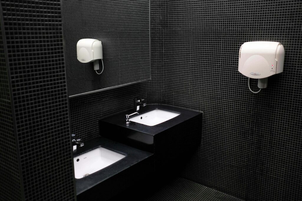 Modern hand dryers installed in a clean commercial bathroom