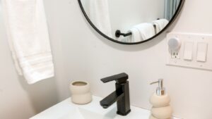Black touchless faucet with matching soap dispenser on a white bathroom sink